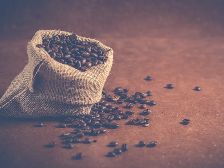 Sac de toile rempli de grains de café torréfiés